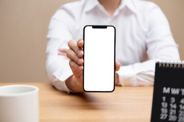 Close up man using smartphone at office desk. Empty screen for your advertising text message