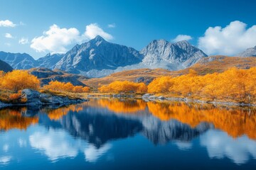 Fototapeta premium Vibrant autumn landscape with mountains reflecting on a calm lake under a clear blue sky
