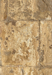 Beige sandstone church wall with large, textured bricks. Historic architecture detail, ideal as a natural stone background or rustic texture for design and creative projects.