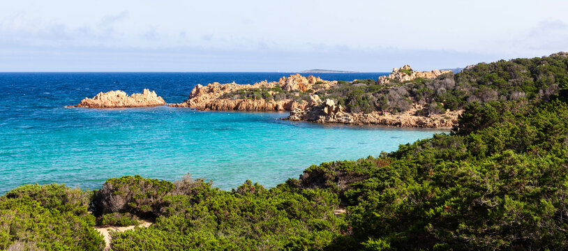 Cala Andreani on Caprera Island, Italy. Stunning Mediterranean landscape. Coastal juniper bushes. Crystal clear turquise emerald blue Tyrrhenian sea. Sardinian landscape.