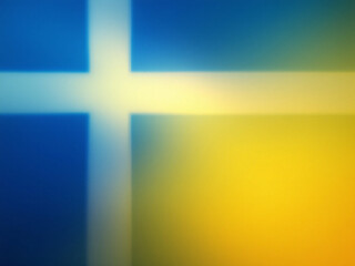 Swedish flag waving against a blue sky with clouds.