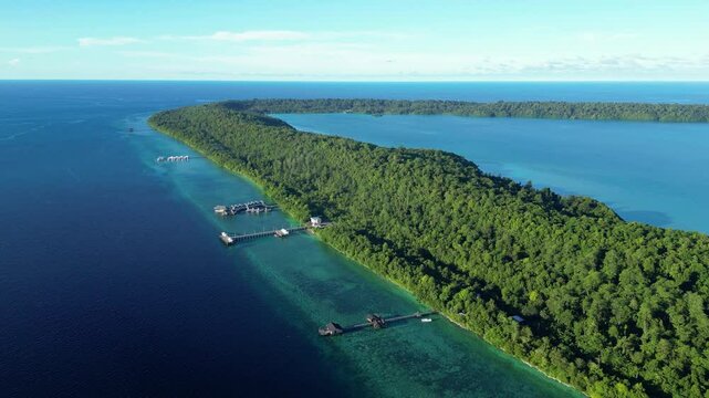 Maratua, Indonesia: Aerial drone footage of resort and overwater stilt bungalow in the with jetty by the reef of the Maratua island in the Derawan archipelago in Kalimantan in Indonesian Borneo. 