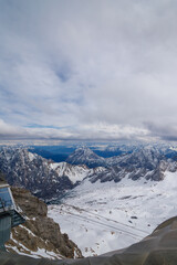Snowy Mountain Range View with Building and Cloudy Sky