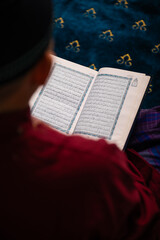 A Muslim Man Reading the Quran During the Month of Ramadan