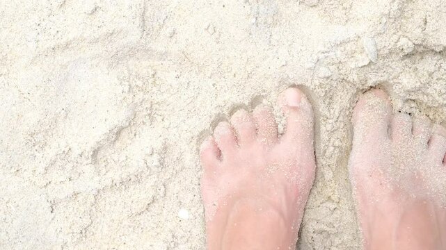 woman walking on snow-white sand, female legs and feet