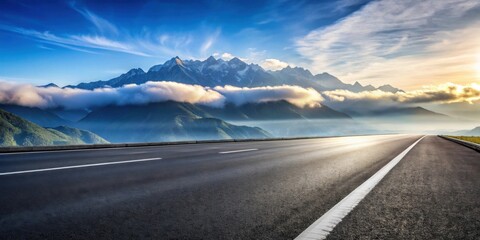 Fototapeta premium Asphalt highway leading to a majestic mountain range shrouded in morning mist and bathed in the golden light of sunrise