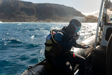 Scuba diver checking bottle pressure on boat before diving in the ocean