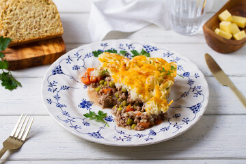 Shepherd's Pie or Cottage Pie on white wooden background. Traditional Irish and British dish