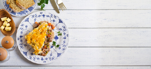 Shepherd's Pie or Cottage Pie on white wooden background. Traditional Irish and British dish. High angle view with copy space