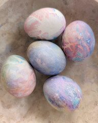  bunch of colorful Easter eggs decorated with various patterns and placed in a bowl at home