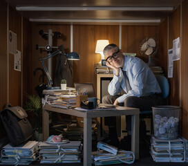 Workaholic businessman working late at night in his small office