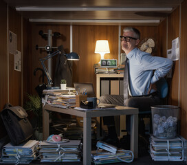 Workaholic businessman working late at night in his small office