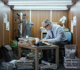 Employee working in a small messy office