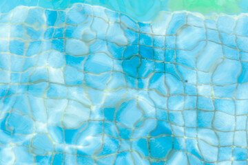 light and ripples distorting swimming pool tiles