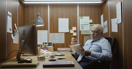 Lazy office worker doing crossword puzzles at work