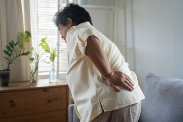 Senior Asian woman suffering from back ache muscle rubbing while walking,  working housework, healthcare and office syndrome problem concept