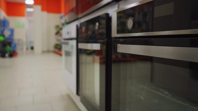 Rear view of an elderly woman in a grey sweater, browsing content on her smartphone. Her hands interact with the screen, suggesting exploration of social media or news in a relaxed indoor atmosphere.