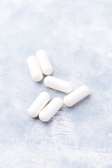 Creatine capsules on bright wooden background. Soft focus. Close up. Copy space.