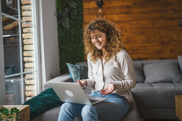caucasian woman use laptop for work and fun in bright living room