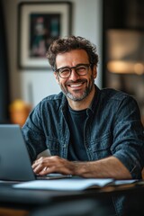 Obraz premium Joyful man enjoying creative work in a cozy home office during pandemic times with laptop and notebook