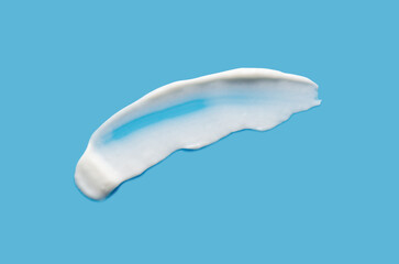 A sample of white cosmetic moisturizer on a blue background