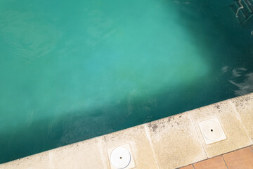 Fototapeta premium light colored pool edge and vibrant turquoise water border