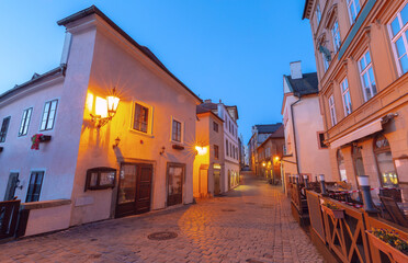 Narrow cobbled street with tower at dawn in old town of Cesky Krumlov Czech Republic