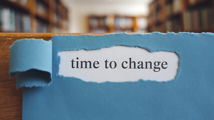 Torn paper reveals time to change against a blurred library background evoking a sense of transformation and knowledge.