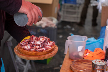 traditional galician cuisine polbo á feira serving octopus dish being seasoned