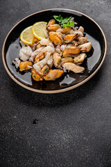 Seafood mix frut de mer mussels, shrimp, prawn, rapan, squid dish fresh gourmet food background on the table rustic food top view copy space keto  paleo diet vegetarian pescetarian diet