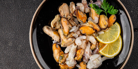Seafood mix frut de mer mussels, shrimp, prawn, rapan, squid dish fresh gourmet food background on the table rustic food top view copy space keto  paleo diet vegetarian pescetarian diet