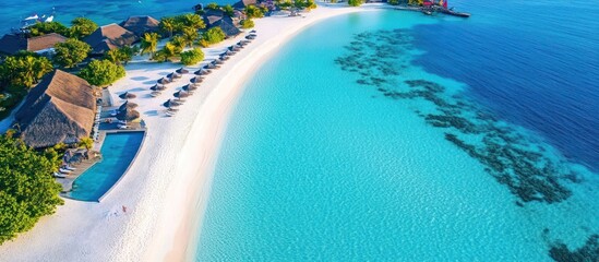 Fototapeta premium Aerial view of a tropical island resort with a pristine beach and turquoise water.