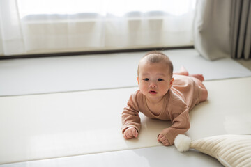 Fototapeta premium Infant lying on floor with natural daylight