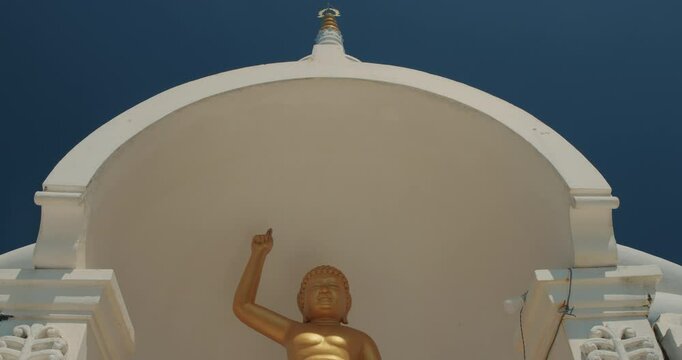 Japanese Peace Temple In Rumassala, Galle, Sri Lanka. Close up Famous landmark and cultural sacred place. The golden statue of Lord Buddha in Parinirvana, Japanese Peace Pagoda. View of the Japanese