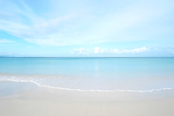 Fototapeta premium A tranquil morning at a serene beach with gentle waves, soft sand, and a calm sea under a clear sky, perfect for peaceful relaxation.