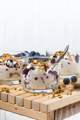 glasses with healthy dessert with blueberries, yogurt and muesli, vertical