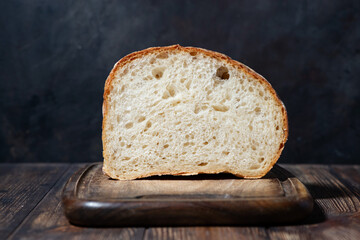 half of white bread on a wooden cutting board, closeup