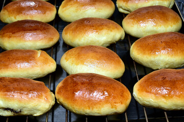 On a baking sheet there are several rows of baked pies with filling.