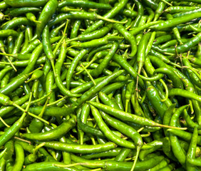 A bunch of green peppers are piled up