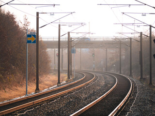Serene winter morning at Ørestad Station, Copenhagen. Curved train tracks lead into the misty...
