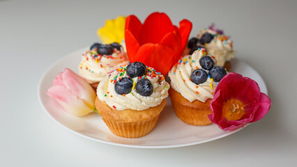 Confectionery products. Cupcakes decorated with cottage cheese cream and tulips. Food and drinks, sweet pastries.