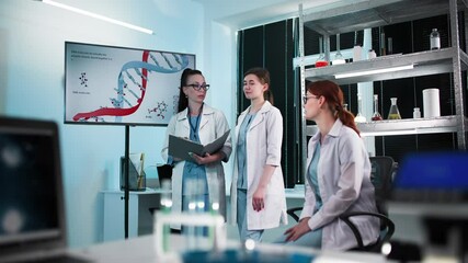 female medical team in surgical gowns conducting medical review of DNA analysis and genetic medicine in hospital office - Powered by Adobe