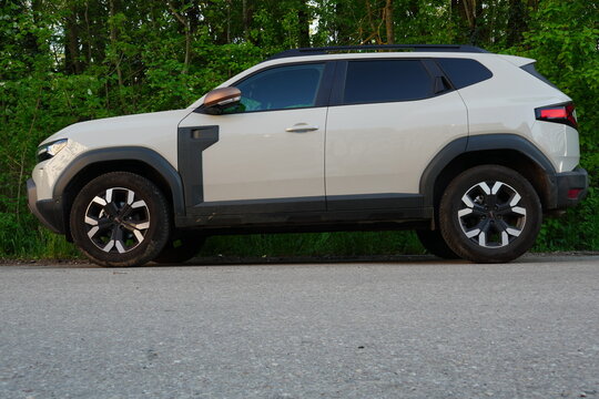 Bucharest, Romania &ndash; April 20, 2025: Closeup side view of Dacia Duster 4x4 car parked on a road along  green forest