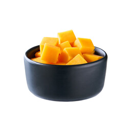 cheddar cheese sliced ​​into cubes in a wooden bowl isolated on a white background.