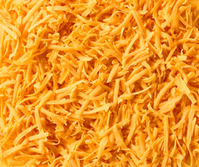 Grated cheddar cheese close up background.