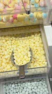 A vibrant display of gummy candies, marshmallows, and sweets at Mercat de la Boqueria, the famous market in Barcelona. The colorful assortment of treats attracts tourists and locals.