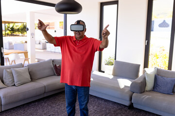 Man wearing VR headset gesturing hands in modern living room, interacting with virtual environment
