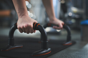 Woman in the gym doing push ups close up shot