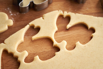 Cutting out bunny shapes from raw pastry dough - preparation of homemade Linzer Easter cookies