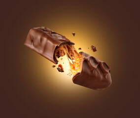 Chocolate bar with nuts crushed in the air on a brown background.